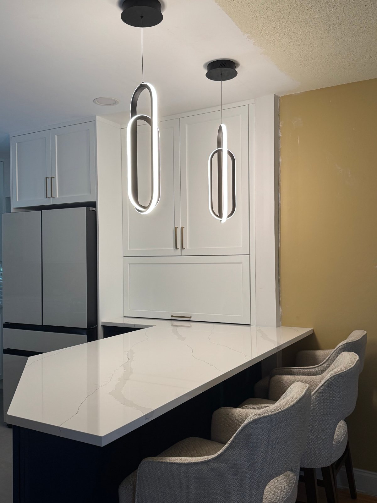 Kitchen peninsula in a Hollywood, Florida residence lit by two oval LED pendants