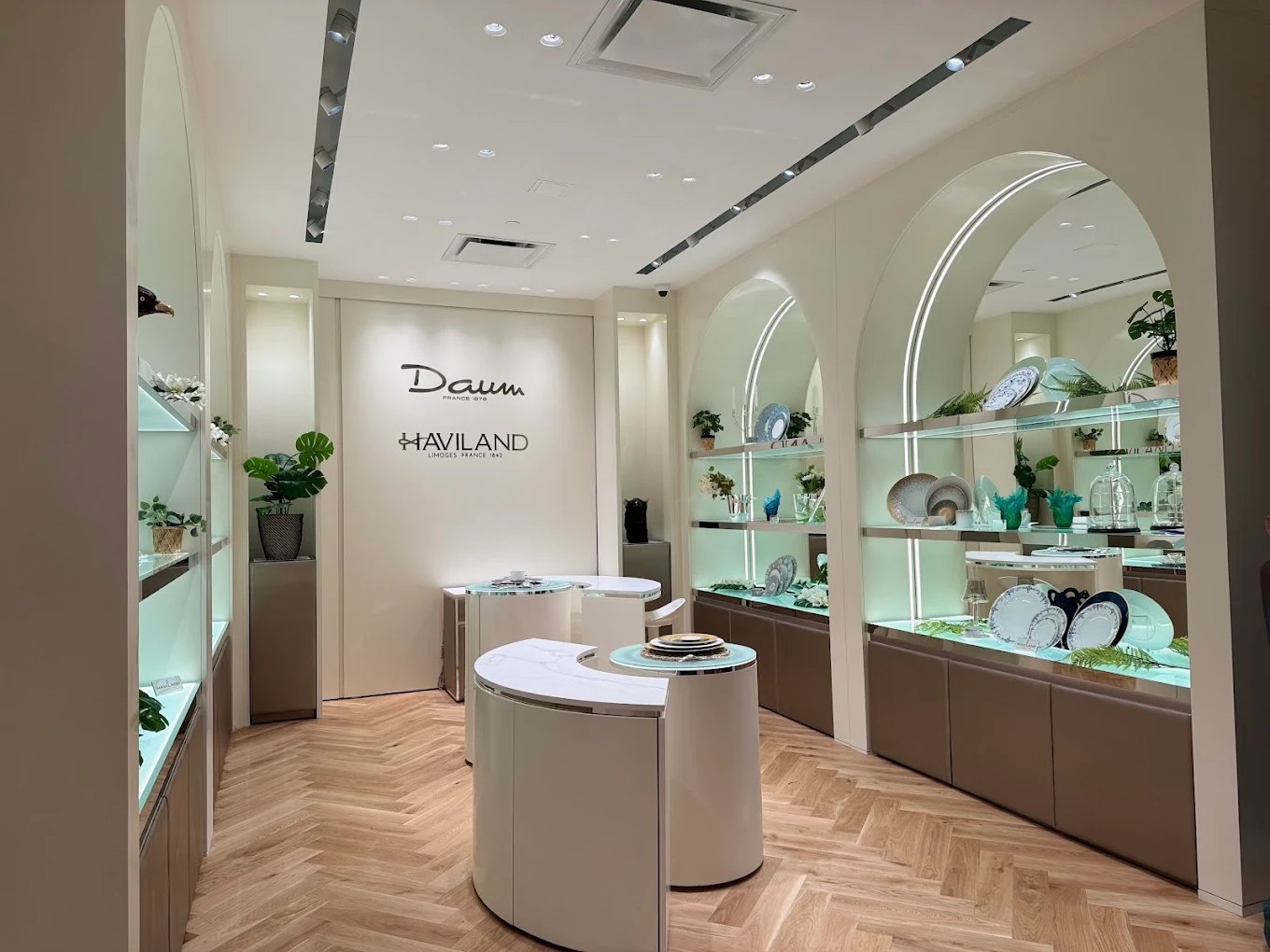 Daum and Haviland boutique at Bal Harbour Shops, with arched display niches outlined in continuous LED and edge-lit glass shelving