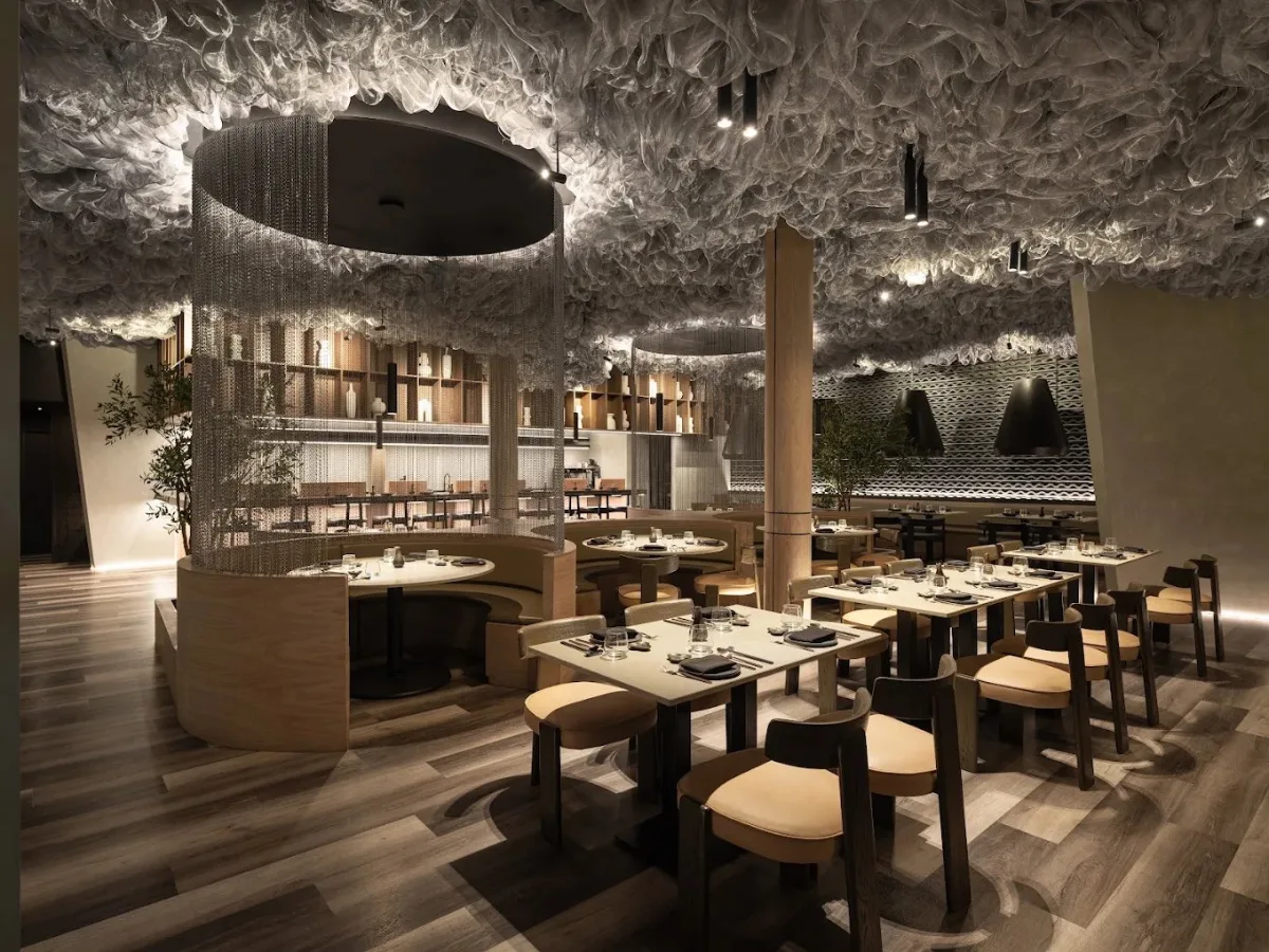 Hikari restaurant dining room in Surfside, Florida, with a sculpted ceiling canopy, chain-curtain cylinder pendant and black cone pendants