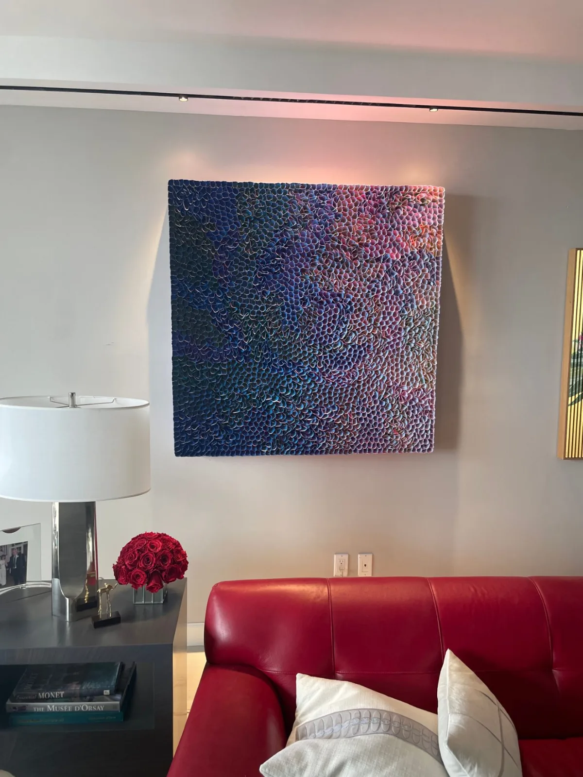 Textured artwork on a Williams Island residence wall, washed by a slim ceiling-mounted linear track
