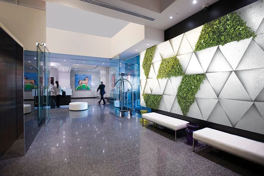 Hotel lobby with living green wall lit by recessed downlights